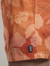 Short de baño con estampado botánico en tonos naranja y coral, con cintura elástica ajustable mediante cordón y malla interior para mayor soporte.