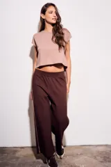 Pantalón deportivo de corte recto y holgado, confeccionado en algodón color marrón chocolate. Presenta una cintura elástica con cordón ajustable y una franja lateral decorativa en tono más claro.