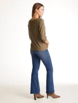 Blusa de tejido acanalado con cuello redondo y mangas tres cuartos. Presenta detalle de tachas metálicas a lo largo de los hombros y mangas, con puños elastizados.