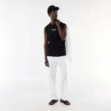 Musculosa negra de algodón con cuello redondo y diseño holgado, con pequeño estampado frontal con texto en blanco.