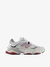 Championes New Balance modelo 9060, con diseño vanguardista inspirado en la estética Y2K. Presenta una combinación de malla y gamuza en tonos blancos y crema, con detalles en rojo y azul marino. Incluye el logo N característico en los laterales y una mediasuela robusta con tecnología de amortiguación ABZORB y SBS.