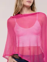 Poncho liviano de tejido de punto fino calado, color blanco, con silueta asimétrica envolvente, escote bote drapeado y mangas integradas estilo capa.