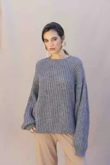 Buzo de tejido grueso en color azul marino, con corte relajado, cuello redondo y mangas largas amplias. Presenta una etiqueta con el logo de la marca en la parte superior de la espalda.