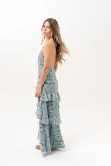 Vestido largo celeste con estampado abstracto en tonos marrones, escote halter con abertura en el frente y volados escalonados en la falda.