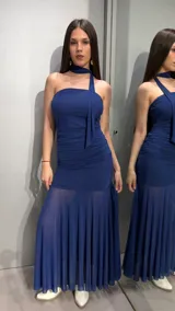 Vestido largo azul marino strapless con fruncidos en el cuerpo, falda de corte sirena con sección inferior transparente y plisada, y detalle de tira al cuello.
