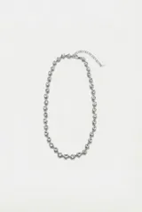 Collar corto tipo gargantilla compuesto por piezas metálicas plateadas en forma de corazón con incrustaciones de vidrio transparente. Cuenta con cadena de alargue y cierre de mosquetón.