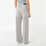 Pantalón de jean gris de corte ancho, con cintura alta y bolsillos delanteros y traseros.