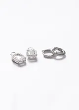 Aros tipo huggies con dije rectangular desmontable, elaborados en plata 925 y decorados con zirconias brillantes en toda su estructura.