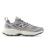 Championes de trail running New Balance modelo 410 v9, color gris con detalles en blanco y gris oscuro. Presentan entresuela con tecnología Fresh Foam para mayor amortiguación, suela con tacos para tracción en terrenos difíciles y refuerzos estratégicos en la capellada para mayor durabilidad.