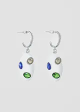 Par de aros colgantes plateados con forma ovalada blanca y tres piedras incrustadas de color verde, azul y dorado.