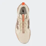 Championes New Balance modelo Tektrel, color beige y marrón, con malla transpirable, superposiciones de gamuza y un sistema de cordones elásticos. Presentan una entresuela voluminosa con diseño geométrico facetado y suela con tacos para tracción.