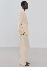 Pantalón wide leg de tiro bajo color beige, con trabillas y dos bolsillos laterales.
