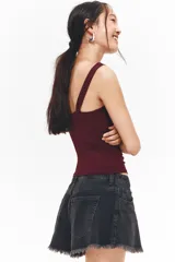 Top de punto elástico color bordó, con breteles anchos que se unen en la espalda. Diseño ceñido con frunces en la parte delantera que crean un leve efecto drapeado.