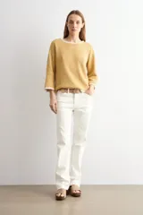 Sweater de punto color mostaza, con escote bote y mangas tres cuartos, con detalles de ribete con encaje en cuello y puños.