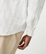 Camisa de corte comfort confeccionada en algodón texturizado con diseño de rayas horizontales finas. Presenta cuello camisero, manga larga con puños abotonados y cierre frontal con botones.