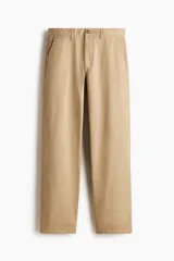 Pantalón de sarga de algodón con corte relajado, cierre de cremallera y botón, bolsillos laterales al bies y bolsillos traseros insertados con botón.