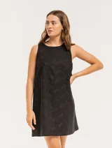 Vestido corto color crema con bordado de lunares negros, sin mangas y con escote redondo.