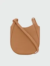 Cartera crossbody Longchamp de la línea Le Foulonné, confeccionada en cuero texturizado color verde militar, con diseño redondeado, asas superiores y correa ajustable con detalles metálicos dorados.