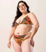 Bombacha tipo colaless de tiro medio, confeccionada en lycra estampada con diseño de hojas tropicales. Presenta terminaciones con puntilla decorativa en los bordes y breteles elásticos regulables en los laterales.