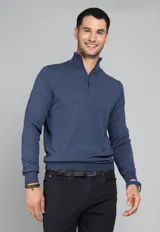 Sweater azul de tejido de punto, con cuello alto y medio cierre frontal con cremallera.