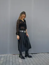 Falda midi evasé de raso color negro, con cintura elástica y cinturón con apliques metálicos.