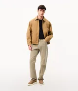 Pantalón recto de sarga color beige, con cierre frontal de botón y cremallera, y bolsillos funcionales.