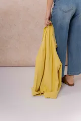 Camisa oversize de denim liviano color amarillo, con cuello camisero, mangas largas con puños, bolsillos delanteros con tapa y ruedo desflecado.