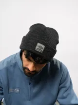 Gorro de lana gris, de punto acanalado con vuelta y parche frontal con el logo de Umbro.