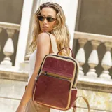 Mochila combinada color verde militar y mostaza, con doble bolsillo frontal y cierre de cremallera. Tiene asa de mano y correas regulables.