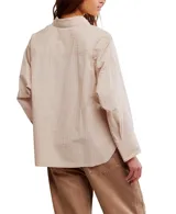 Camisa de algodón a rayas verticales azules y blancas, con cuello clásico, cierre de botones frontal, un bolsillo en el pecho y mangas largas con puños abotonados.