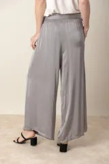 Pantalón palazzo negro de rayón y viscosa, con cintura elastizada, lazo y bolsillos laterales.