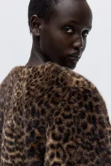 Campera de piel sintética con estampado de leopardo, cuello redondo y cierre frontal con botones. Presenta un diseño de corte recto y forro interior.