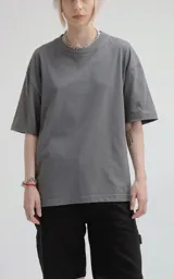 Remera de corte holgado y diseño minimalista, con cuello redondo y mangas cortas de hombros caídos. Confeccionada en algodón premium, presenta un largo a la altura de la cadera.