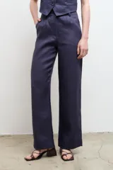 Pantalón de vestir color beige, de corte recto y tiro alto, confeccionado en lino 100% con bolsillos laterales.