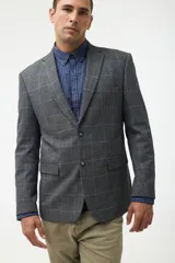 Blazer de corte sastre en color gris con estampado de cuadros en tonos azules. Presenta cierre frontal de dos botones, solapas clásicas y bolsillos laterales con solapa.