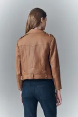 Campera estilo biker confeccionada en cuero ovino, con solapas amplias, charreteras en los hombros y cinturón ajustable en la cintura. Presenta cierres metálicos en el frente y bolsillos laterales, con forro interior de poliéster.