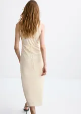Vestido midi recto color beige sin mangas, con cuello en V con solapa de volantes bordados y cordones entrecruzados en el escote.