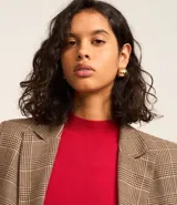 Suéter negro de punto con cuello alto, mangas largas abullonadas y puños largos.