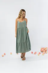 Vestido largo de corte amplio con breteles finos y escote en V. Presenta un diseño escalonado con vuelo en el ruedo, confeccionado en gasa de algodón liviana con textura.