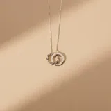 Collar de plata 925 con dije compuesto por dos aros entrelazados, uno de superficie lisa y otro con diseño trenzado.