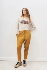 Pantalón estilo babucha de corte relajado, con cintura elástica y cordón ajustable. Presenta bolsillos diagonales en el frente y puños ajustados en los tobillos.