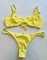Conjunto de bikini amarillo con corpiño con aros y vedetina con tiras ajustables.