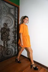 Vestido corto color verde oliva, de manga corta y corte holgado con frunce en la cintura que genera un efecto de falda globo (balloon).