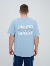 Remera Umbro de manga corta, color celeste, con cuello redondo y el logo de la marca bordado en el pecho.