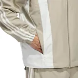 Campera rompevientos adidas Originals Basketball, de diseño urbano en color beige con paneles frontales y laterales en blanco, cuello alto y cierre frontal con cremallera. Incluye el logo del trébol bordado en el pecho.