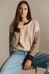 Sweater de punto con diseño color block en tonos beige, marrón y bordó, de cuello redondo y manga larga con puños acanalados en contraste.