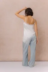 Musculosa de satén color crema con breteles finos regulables, escote en V y detalles de encaje en el escote, en diagonal sobre el delantero y en el ruedo.