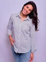 Camisa entallada de algodón con diseño de rayas verticales finas en color azul y blanco, cuello camisero, manga larga y cierre frontal de botones.