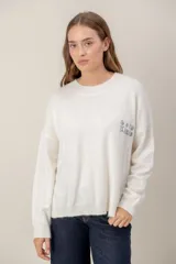 Sweater de punto color blanco, de corte holgado y cuello redondo, con bordado en el pecho que dice 'GOOD KARMA'.