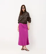 Pollera midi de satén de viscosa color fucsia, con cintura alta y modelado ajustado con leve evasé. Incluye cinturón ancho con hebilla.